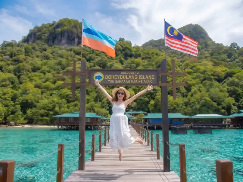 Walking along the wooden boardwalk at Bohey Dulang Sea Coral Resort