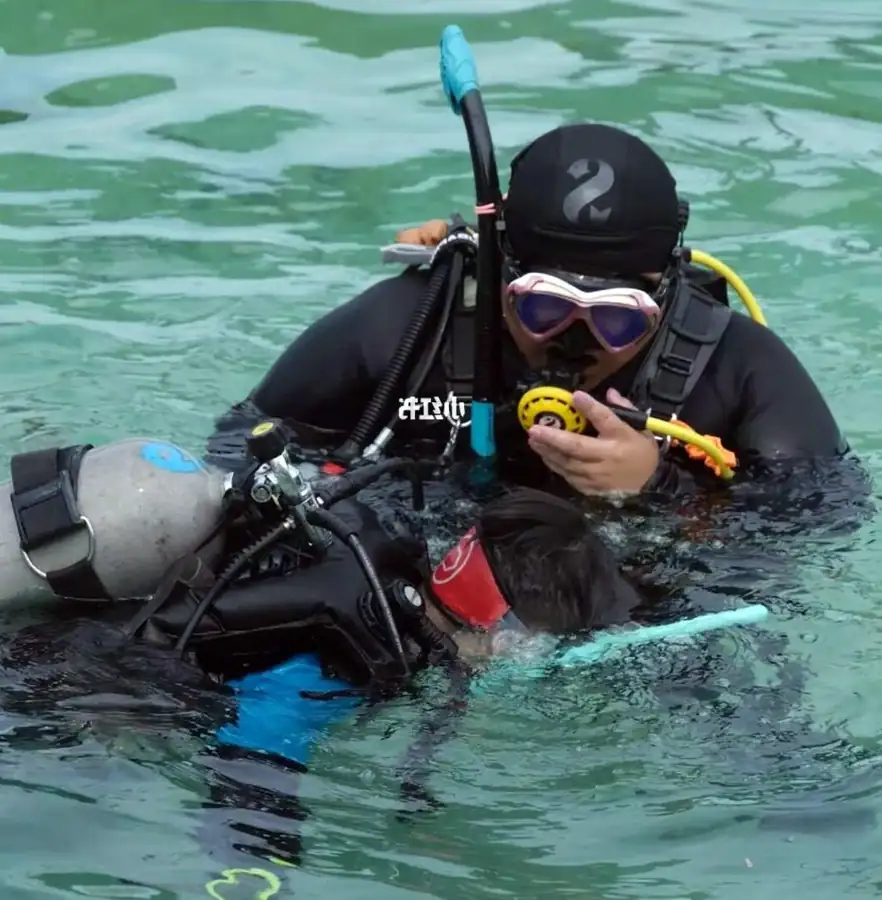 Children learning scuba diving in the shallow waters Sea Coral Resort